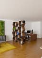 wooden floor, white walls, black leather chairs, yellow rug, table, office desk with computer, open shelving unit, kitchen with oven