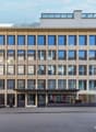 modern office building, multiple windows, large glass entrance, multiple floors, beige color, garage