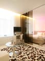 modern room with white and brown checked floor, white sofa, glass table, desk with computer, tv
