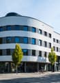 modern architectural style, large windows, ArcoWest name, glass entrance
