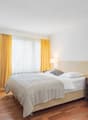 Bed, table, chair, lamp, window, nightstand, yellow curtains, flowers