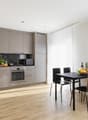 modern kitchen, wooden floor, kitchen island, gas stove, microwave, dishwasher, sink, grey cabinets, dining table with 4 chairs