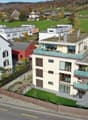 4 story building, modern style, multiple balconies, green rooftop, outdoor seating area, nearby green space