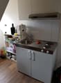 Compact kitchen with sink, induction cooktop, dishwasher, under cabinet fridge, overhead extractor
