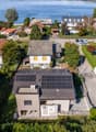 House with solar panels on the roof, located on the lakefront, red tile roofs, fenced gardens