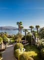 balcony with ocean view, lawn, trees, mountains, mountains in the distance