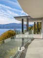 building exterior, glass railings, lake view, terrace, mountains in background