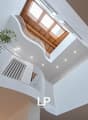 curved staircase, white railings, wooden ceiling, skylights, plants