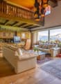open-plan living and dining room with fireplace, balconies, glass windows with balcony railing, floor-to-ceiling windows, large glass windows, glass doors, couch, glass coffee table, rug, cabinet, TV