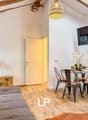 Sofa, dining table with 4 chairs, lamp, TV, wooden floor, wooden beams, wooden box with plant, rug