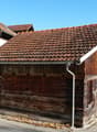 Wooden house, raised ground floor, brown roof, mountain view