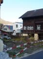 brown wooden house, gable roof, multiple windows, mountains in the background