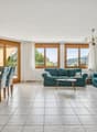Grosse Fensterflächen und Terrassenzugang verbinden Innen und Aussen
