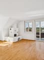 Ein Ort zum Ankommen: Heller Wohnbereich mit Balkon und behaglichem Cheminée