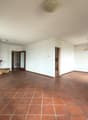 large empty room, brick fireplace, terracotta tiles, white walls, ceiling lights