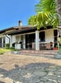 single story house, white exterior, red tiles, large patio, outdoor seating area, palm tree