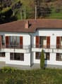 two story house, white, brown roof, windows, balcony, garden