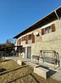 Raised ground floor house, stone walls, wooden windows, porch, garden, swing, benches