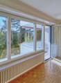 large windows, wooden floor, white walls, balcony, trees view