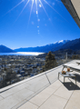 Terrace with lounge chairs, table, and a view of the city and lake