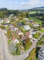 Residential area with single-family houses, solar panels on roofs, driveways, and driveways with speed limit signs