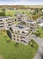 Multiple residential buildings, solar panels on roofs, landscaped gardens, wide open fields, surrounding trees, driveway
