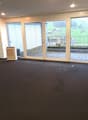 empty room, black floor, white walls, sliding glass doors, balcony, air conditioner, view of a green field