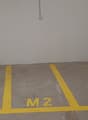 Concrete floor, labeled parking spaces M1, M2, M3, power outlets on the wall