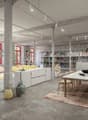 Modern and industrial designed interior with large open space, tables, chairs, couches, carpets, lamps, shelves, and people