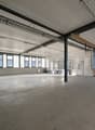 empty room, concrete floor, windows, metal ceiling beams, storage shelves