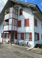 2 story house, white exterior, red shutters, balcony, car parked in front
