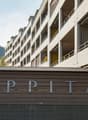 Apartment building with multiple floors, balconies, and a sign reading 'APPITAL'.