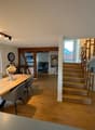 Dining room: Wooden table and chairs, staircase, glass windows, wooden floors