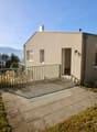Raised single story house, concrete floor, glass entrance, large windows, pathway