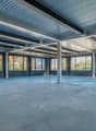 Empty room with metal ceiling, large windows, and concrete floor