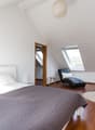 bedroom with a bed, pillows, duvet, and white rug