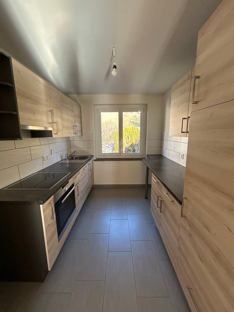 wood cabinets, black countertops, stainless steel sink, oven, double sink