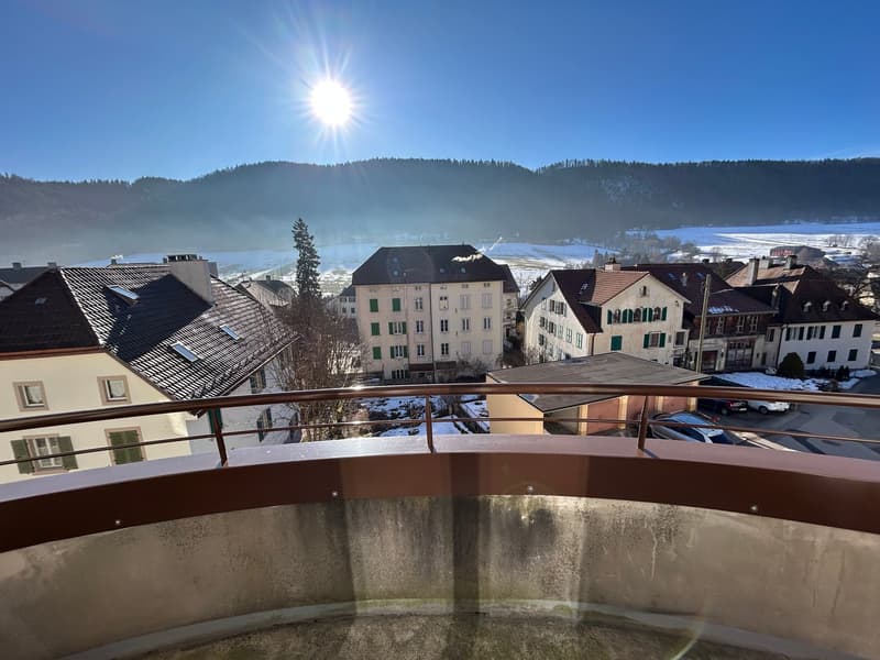 Aerial view of a town with houses and mountains, on a sunny day