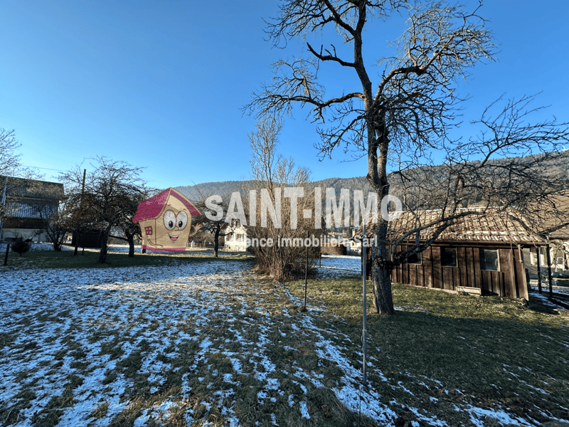 Two story house, red brick, brown roof, garage, snow, trees, mountains