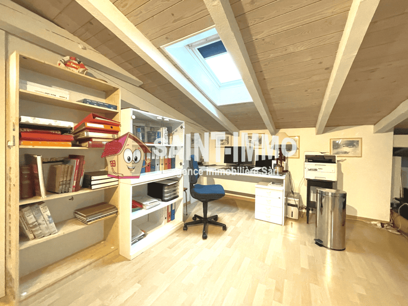 Room with desk, bookcases, office chair, printer, and a window with view.