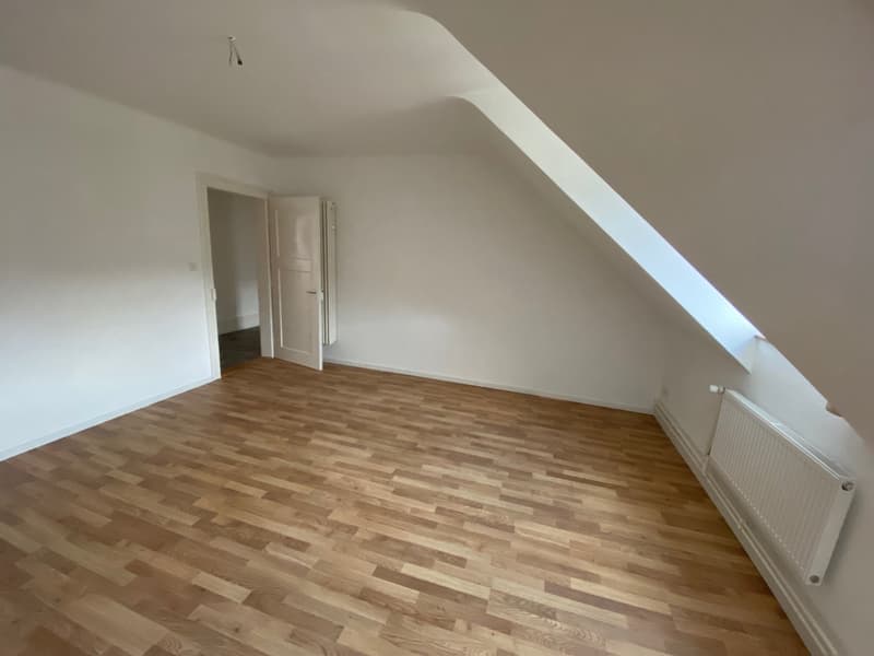 empty room, wooden floor, white walls, small window at the back, white door, window