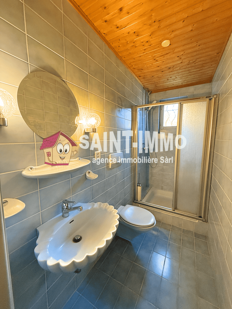 tiles, shower, sink, toilet, wall mirror, wooden ceiling, wall lamps