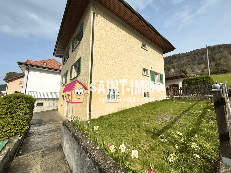 3 story house, yellow exterior, red roof, green shutters, driveway, garden, mountain view
