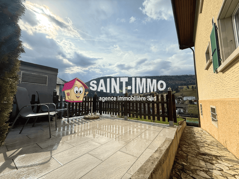 Terraced house, wooden fence, tiled terrace, two chairs, mountain view