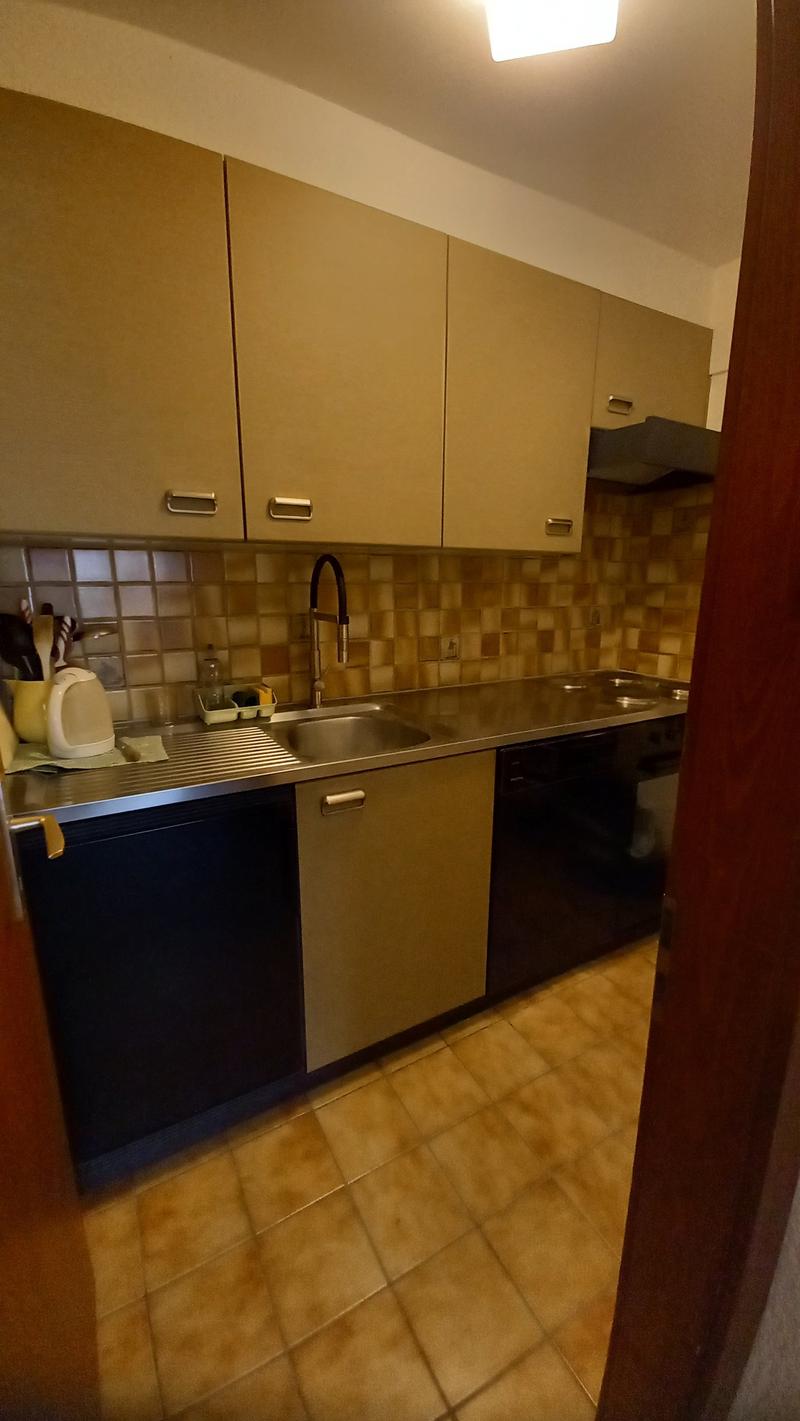 kitchen with tiled floor, stainless steel countertop, sink, faucet, cabinets, dishwasher, stove