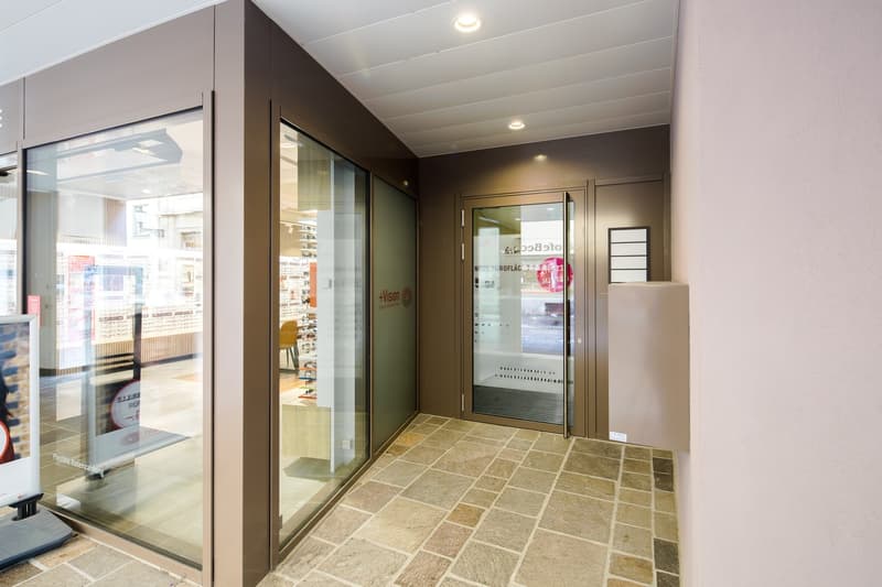 Entrance with glass doors, tiled floor, and a small bench