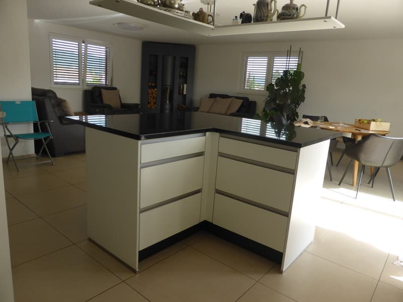 kitchen with central island, black and white countertop, white cabinets, modern design, dining area with chairs and table