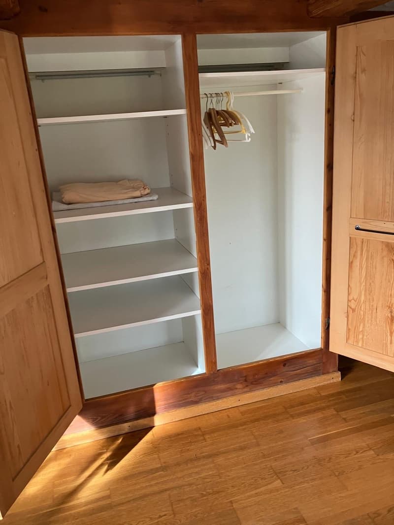 empty wood-designed wardrobe with shelves and clothing hangers