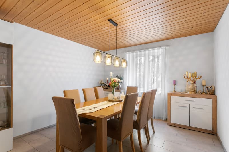 Dining room with 8 chairs, wooden table, wooden floor, chandelier, dining table mat, cabinet, flower vase
