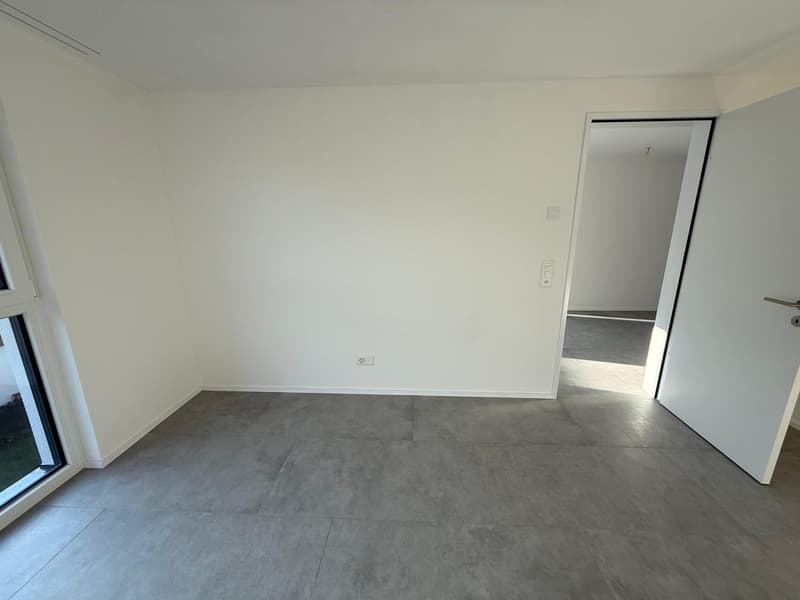 empty room, white walls, gray floor, two doors, one with window